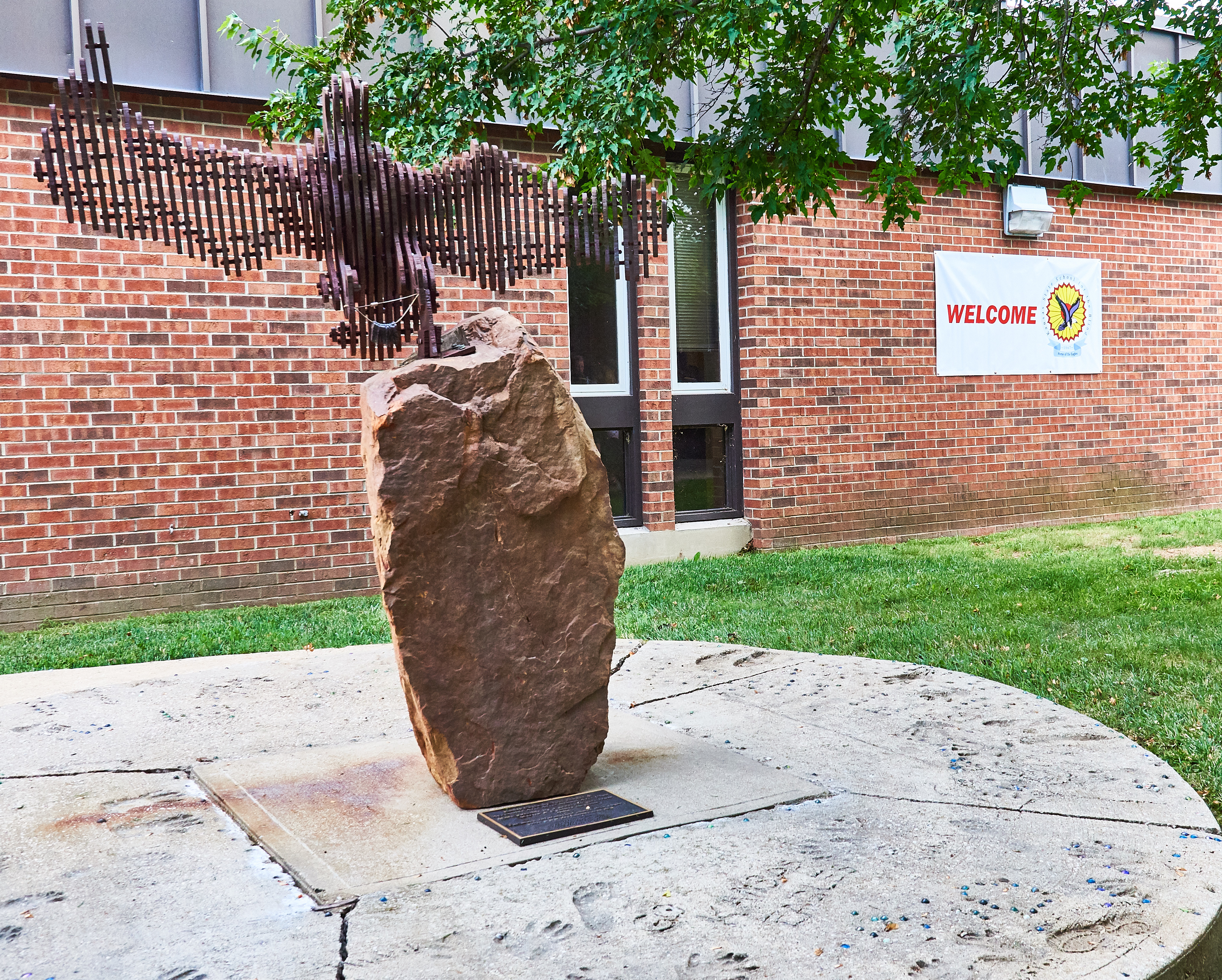 Flying Eagle Sculpture made out of wood on top of a large boulder. Located on KSSB Campus near sensory garden.