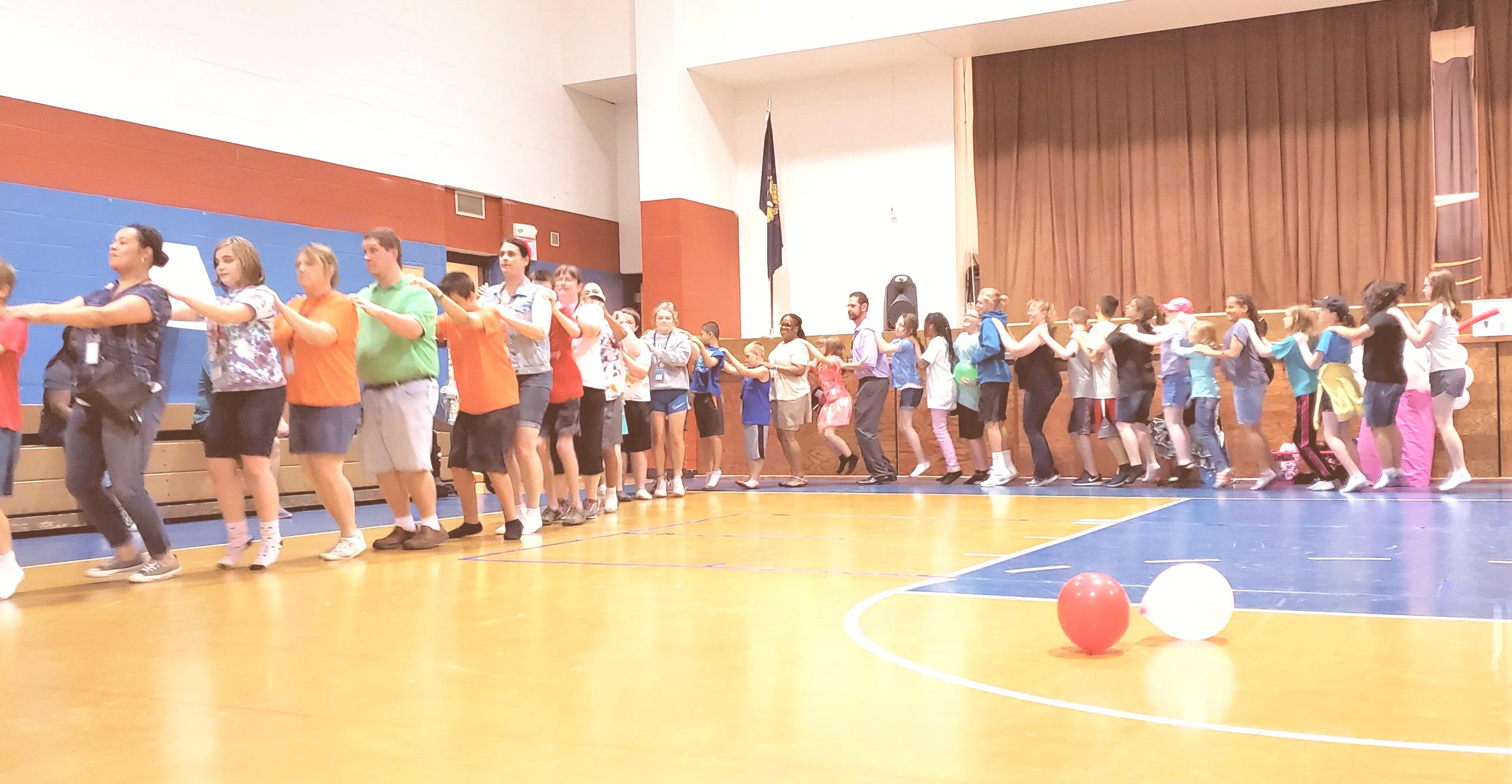 students form a conga line in the KSSB gym