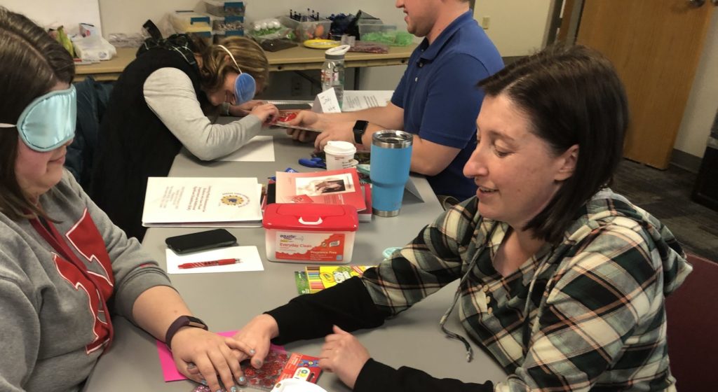 Two teachers take turns under blindfold, learning about hand under hand