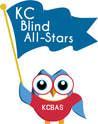 Owl wearing KCBAS shirt holding a flag that reads KC Blind All-Stars