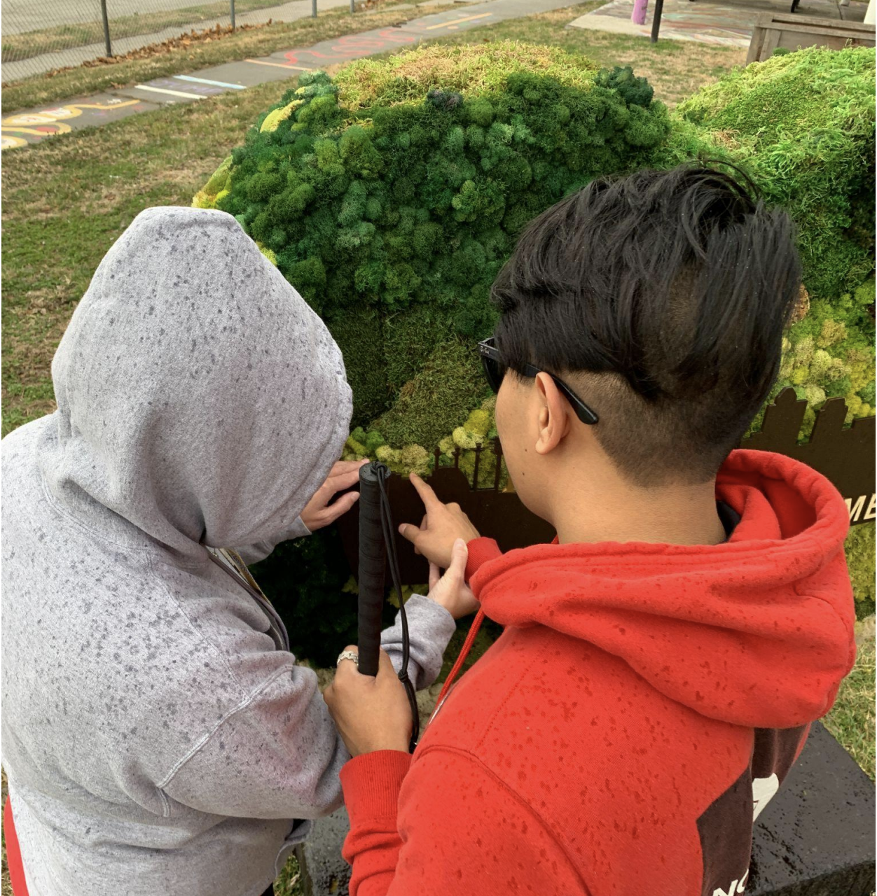 KSSB student and teacher feeling the moss on a large heart in a park in Kansas City, KS