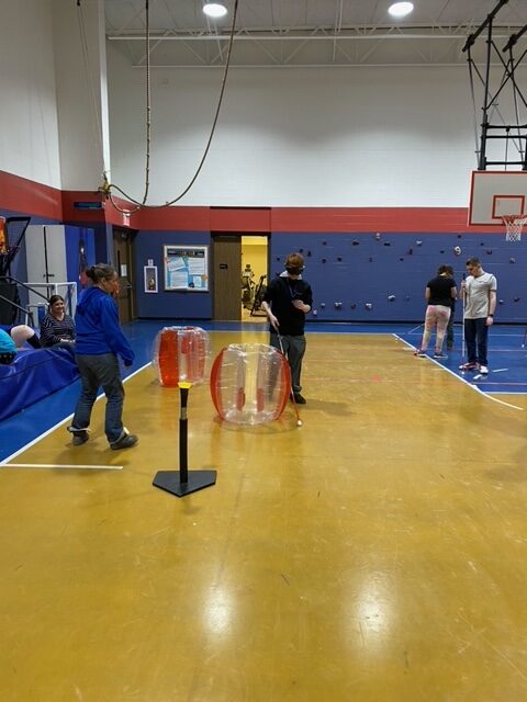 students, holding canes, navigate through an obstacle course