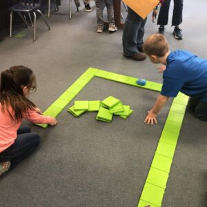 Two students work together on building a coding mouse.